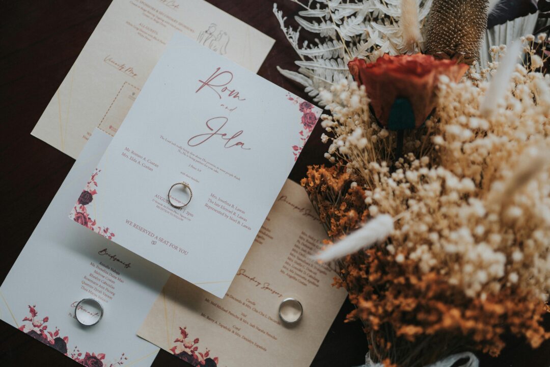 Terracotta wedding bouquet with rust dahlias, dried pampas grass, strawflowers, olive branch greenery, and cream garden roses in an organic, unstructu