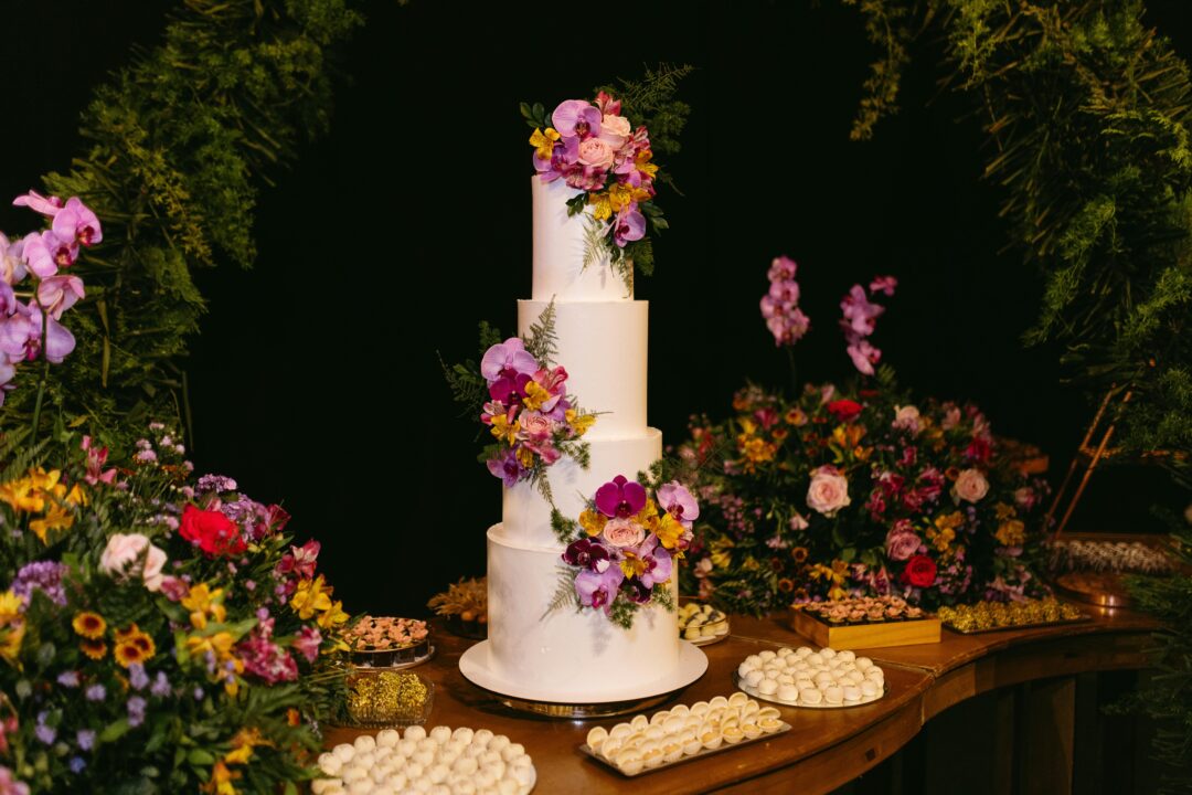 wedding reception buffet station with elegant signage, tiered serving platters, and floral accents - guests serving themselves at a styled food statio