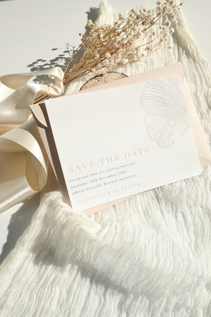 Paperlust blush save the date card with embossed botanical motif styled with baby breath and silk ribbon