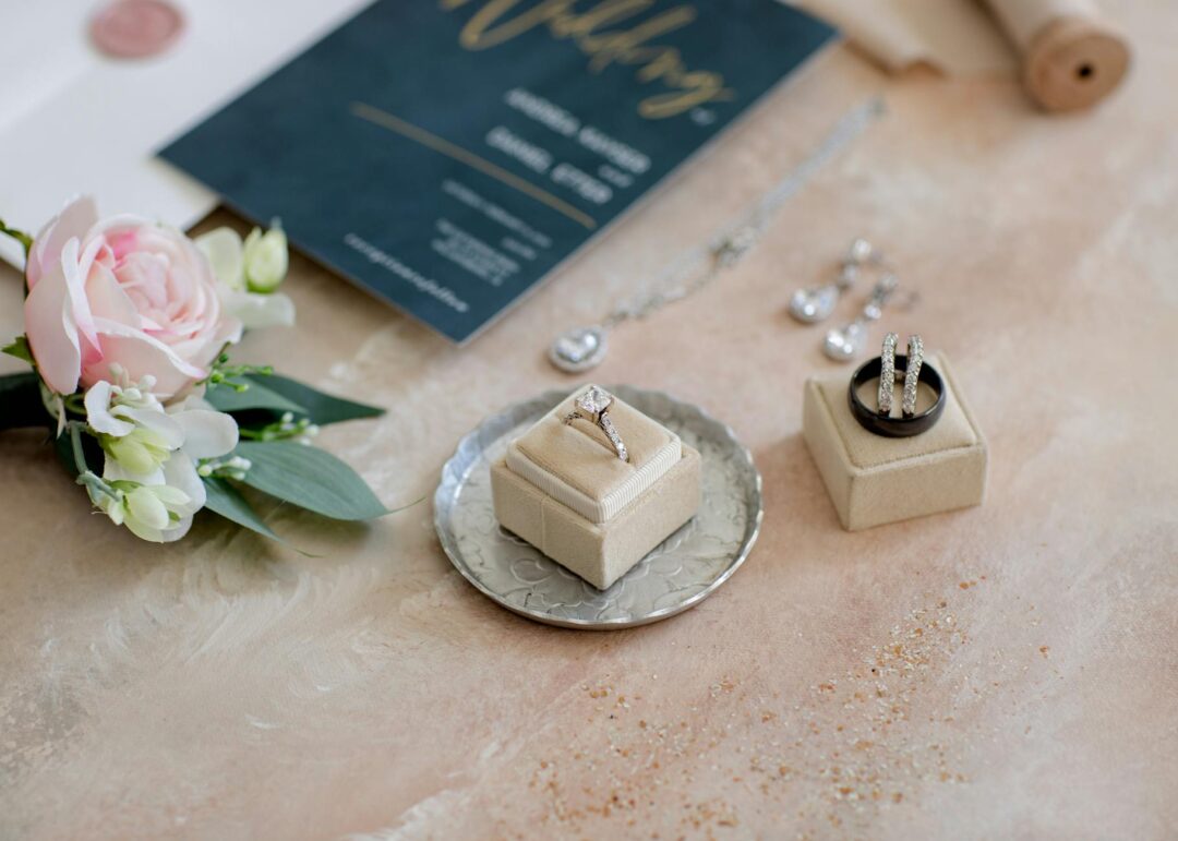 Elegant micro wedding invitation suite styled on a marble surface with greenery sprigs, two invitation cards side by side