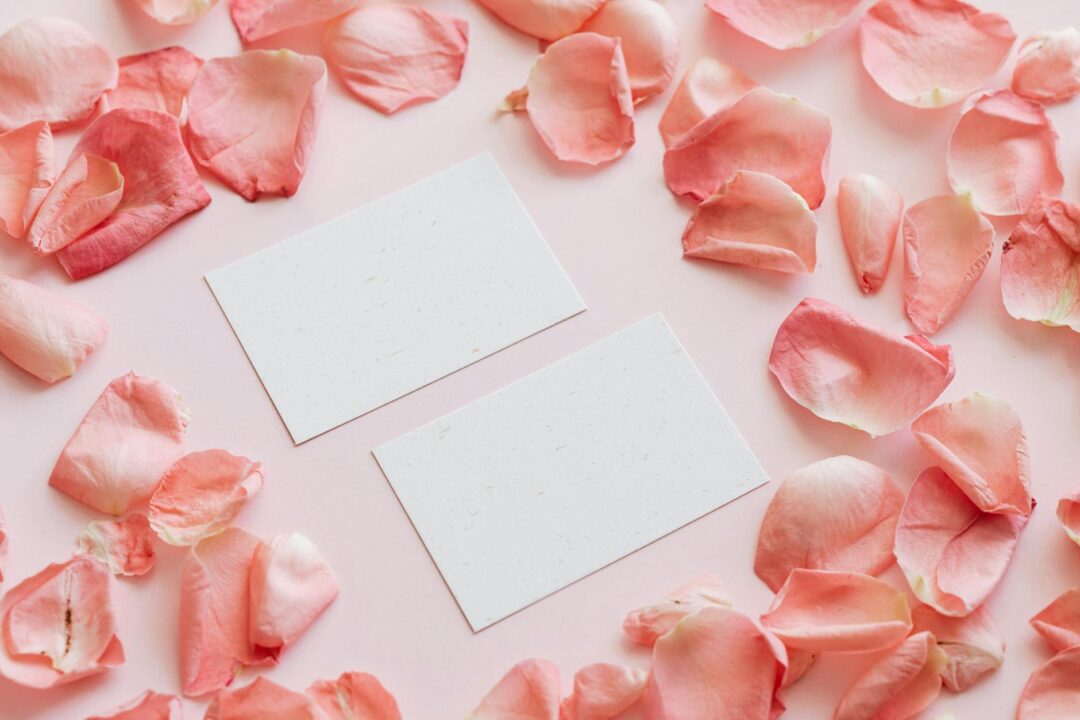 Flat lay of letterpress wedding menu cards showing debossed typography on thick cotton paper stock with gold ribbon detail