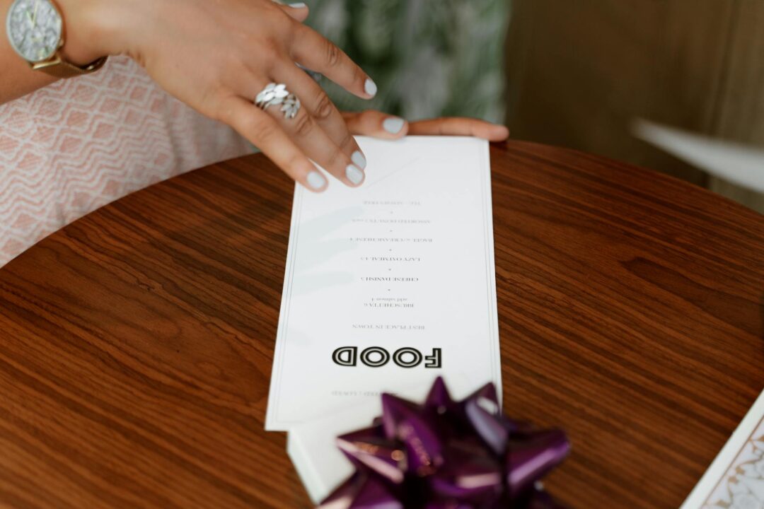 Close-up detail of a wedding menu card showing dietary symbols and elegant typography on premium paper stock