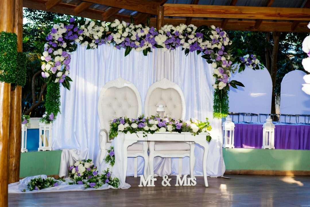 wedding arch repositioned as sweetheart table backdrop at reception dinner, candles and florals on table in foreground