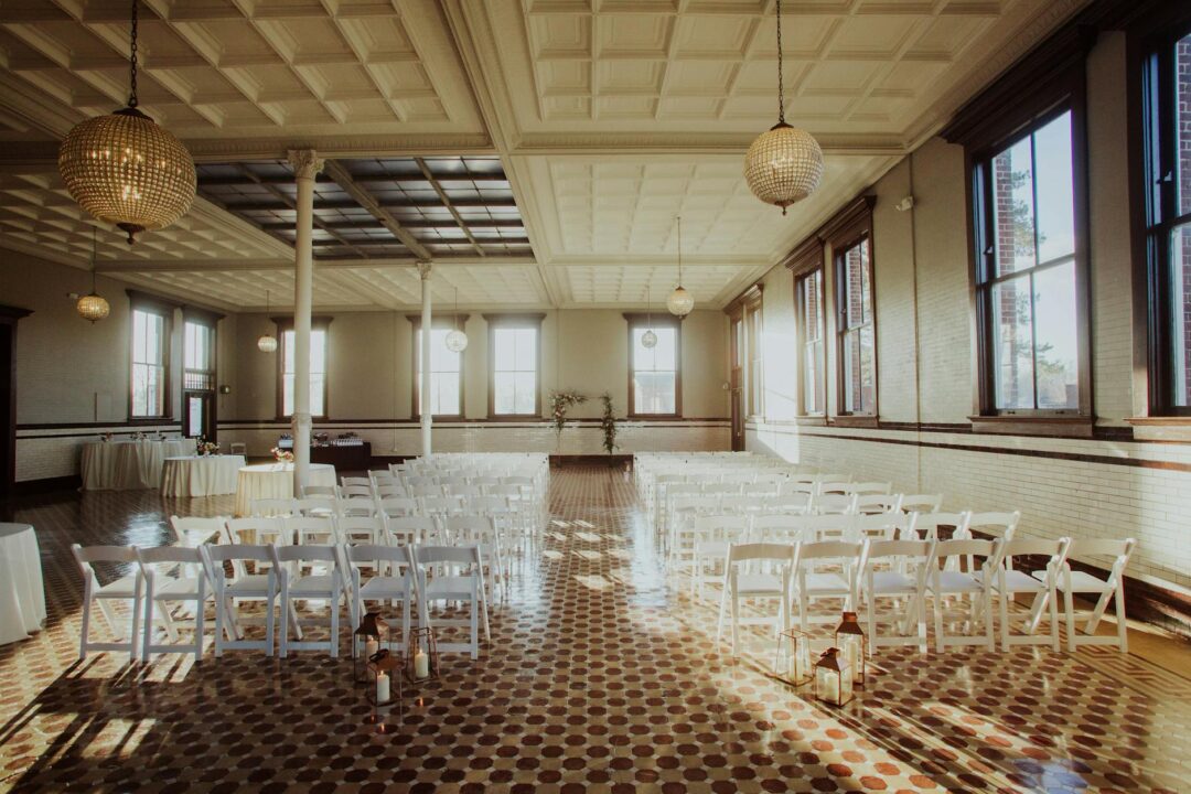 indoor wedding ceremony with sheer fabric ceiling draping and warm fairy lights creating soft romantic ambiance