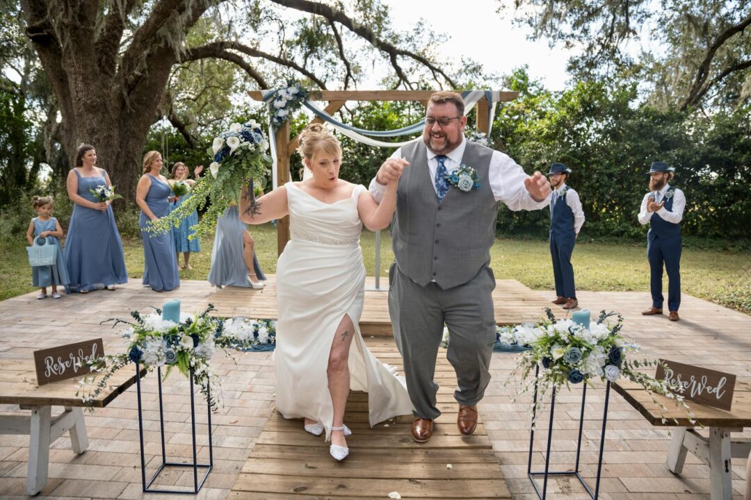 wedding florist moving arch floral arrangement from outdoor ceremony to reception room as centerpiece backdrop