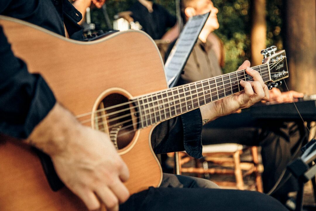 ceremony string quartet or solo guitarist performing at outdoor wedding, candid