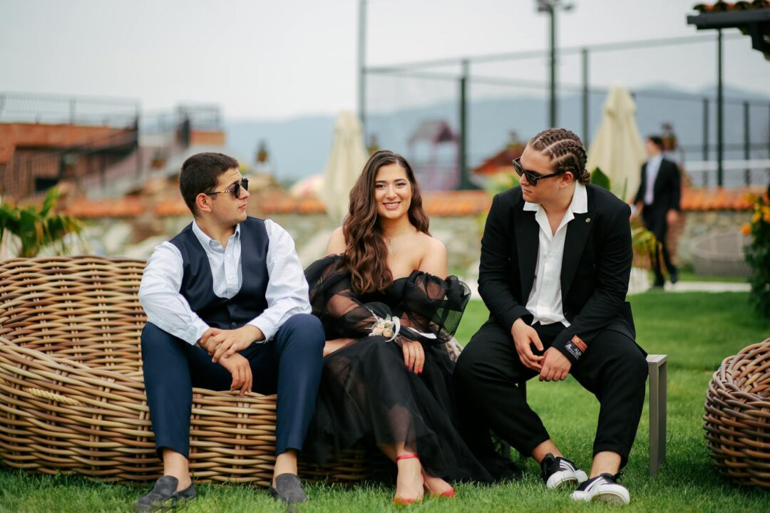 wedding cocktail hour on a summer lawn with guests playing giant Jenga, drinks in hand, bridesmaids laughing, warm afternoon light