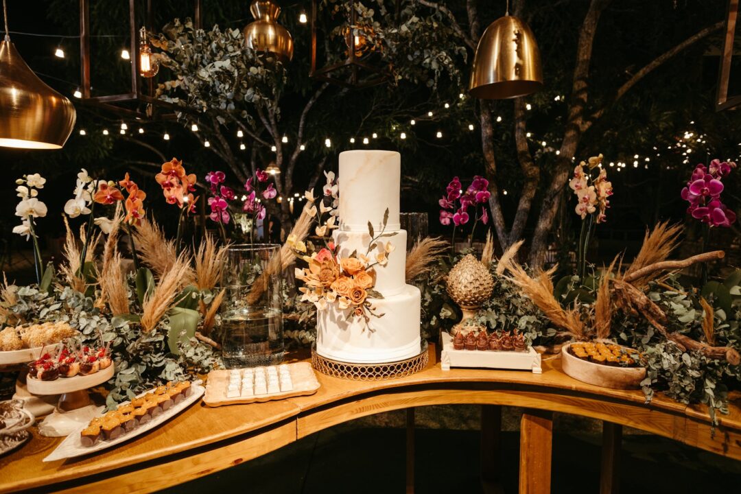 relaxed late-night wedding dessert station with warm cookies on a wooden board, small milk bottles, twinkle lights in a barn reception venue
