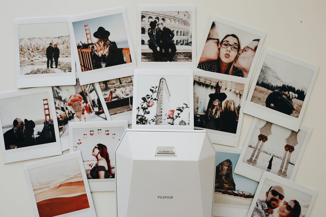 Wedding photo display wall with instant photos clipped to hanging string lights
