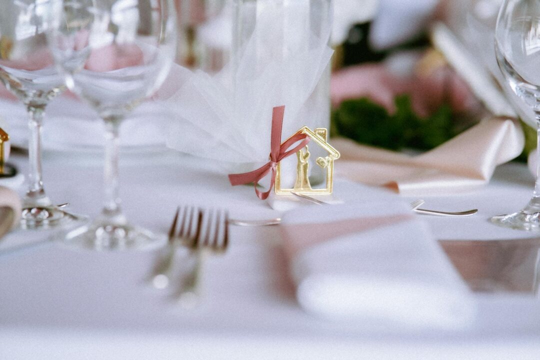 wedding reception detail, table setting with menu cards, place cards, centerpiece florals, warm candlelight, editorial styling