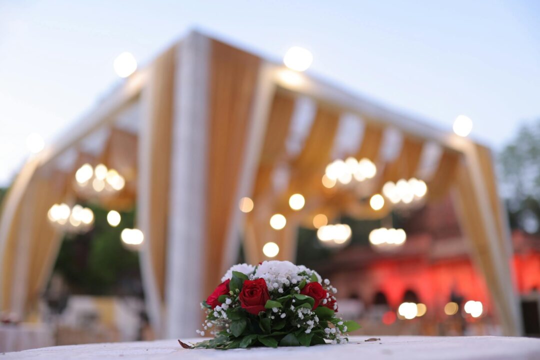 Jewish wedding huppah canopy decorated with flowers, ceremony setup at altar, intimate venue with warm lighting
