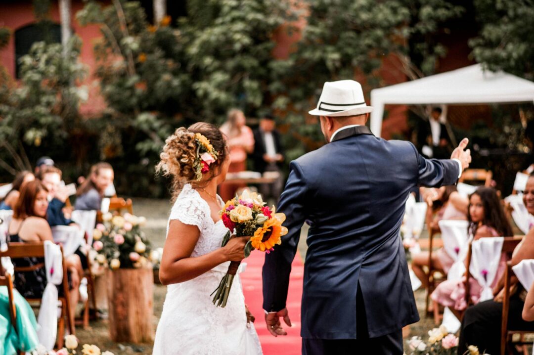 newlywed couple walking back down the aisle, guests throwing petals, joyful recessional exit moment