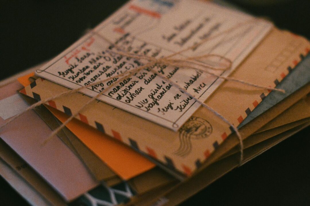 stack of wedding programs tied with twine, close-up detail, warm wood surface
