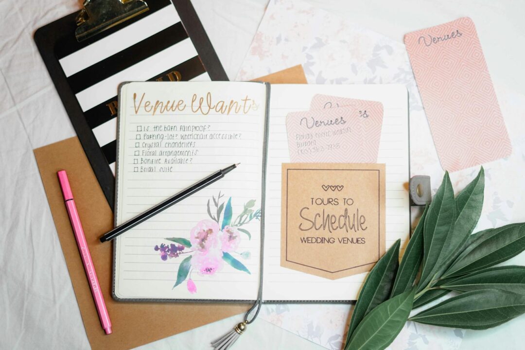 Wedding venue planning notes in open notebook on desk