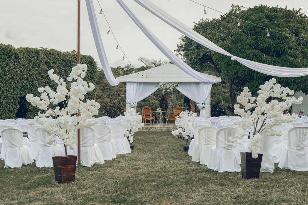 Outdoor garden wedding ceremony with lush floral arch