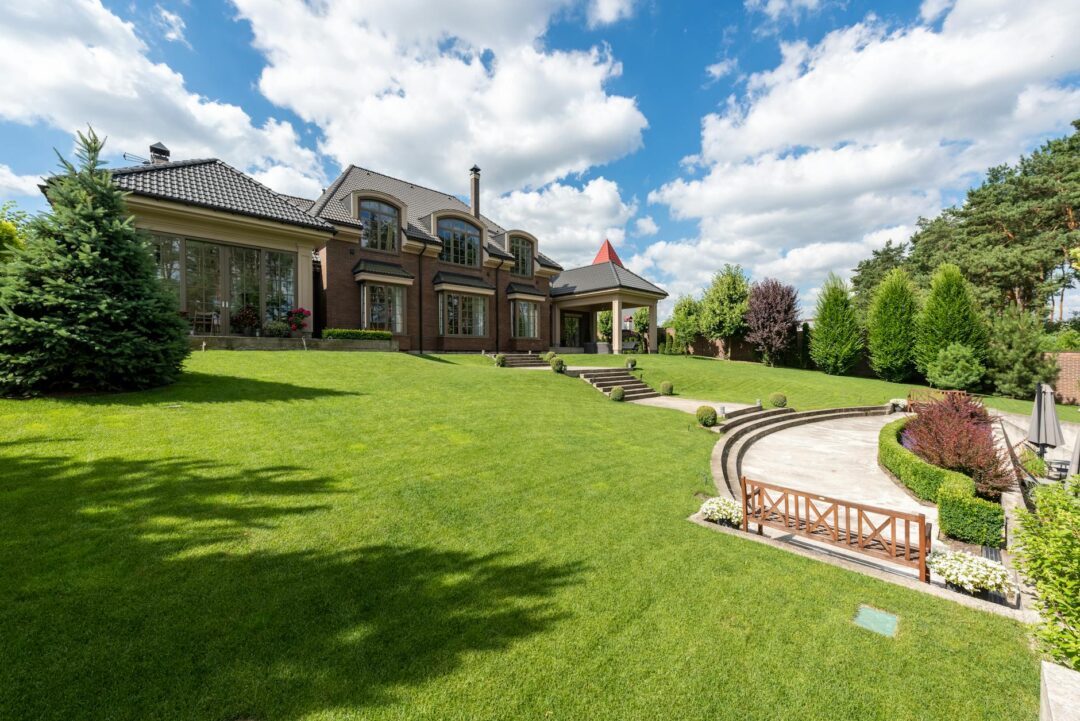 Outdoor estate wedding ceremony with mansion in background