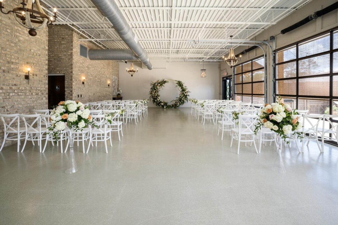 Garden wedding ceremony under white rose arch with oak trees
