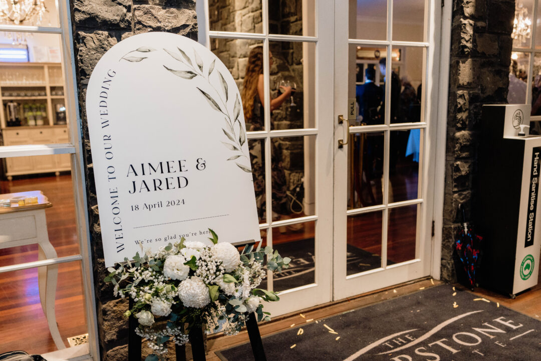Paperlust large arch-shaped sage green wedding welcome sign at reception venue
