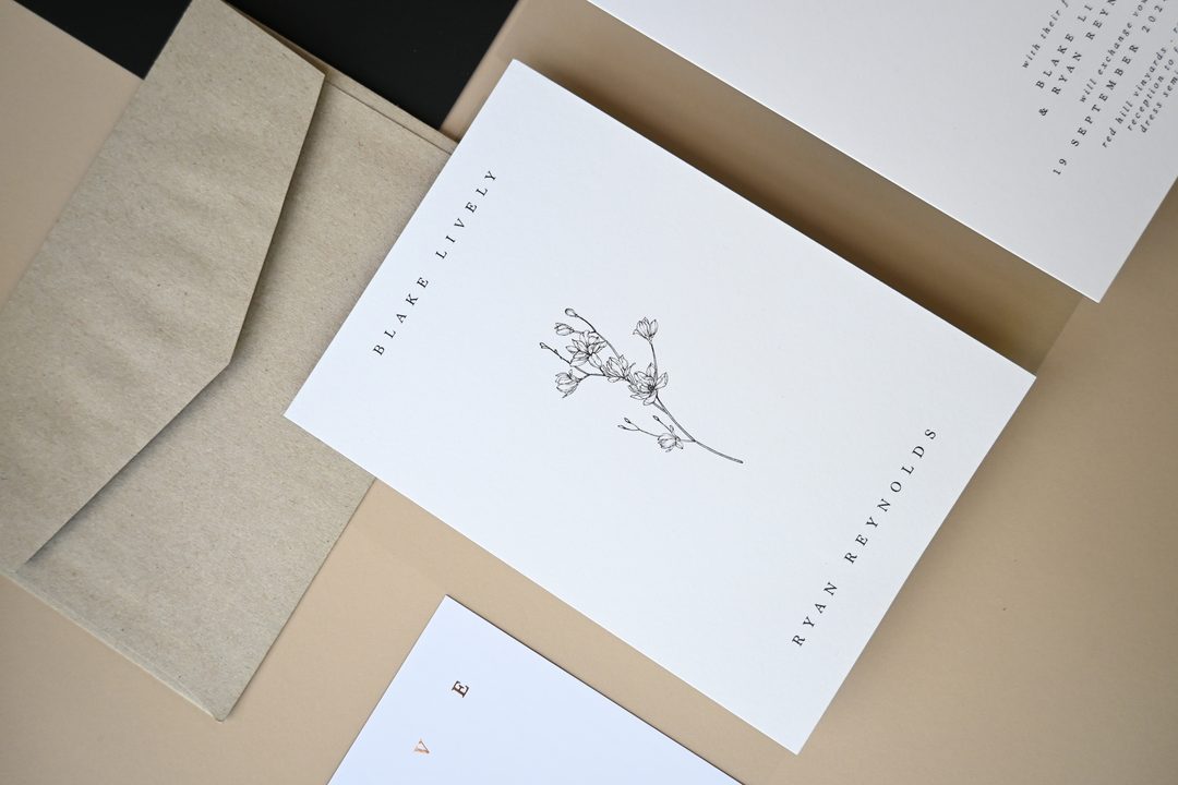 A Paperlust elopement announcement card suite laid on a pale marble surface.