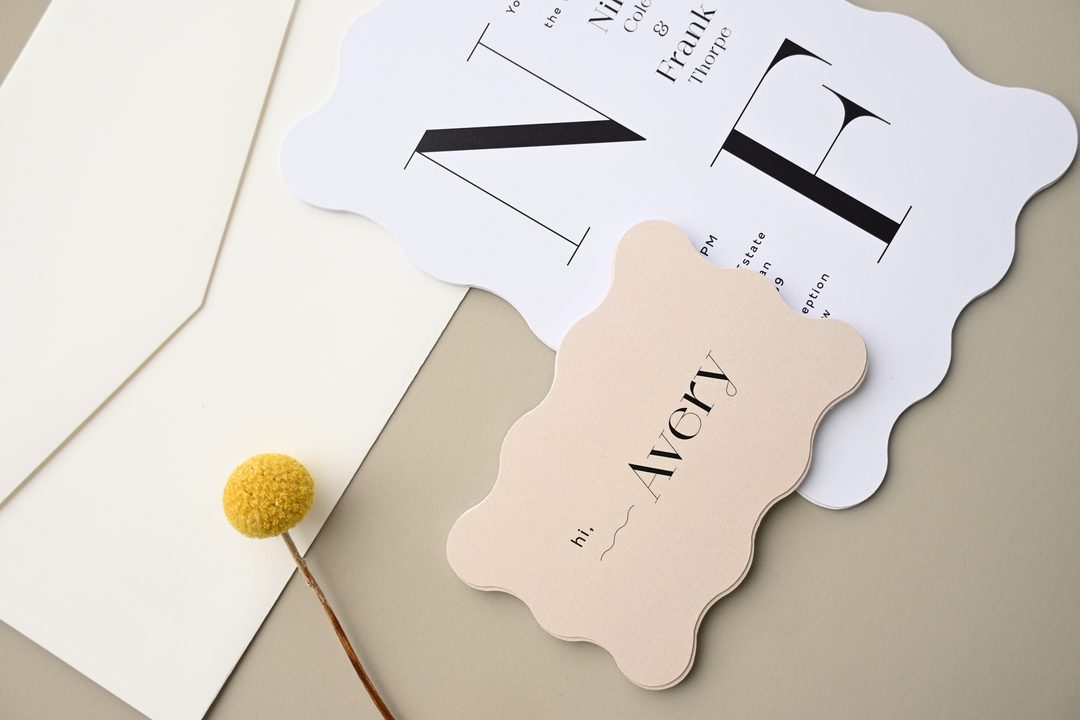 Paperlust invitation, Beautifully styled flatlay featuring a wavy-edged place card and wedding invitation with bold serif typography