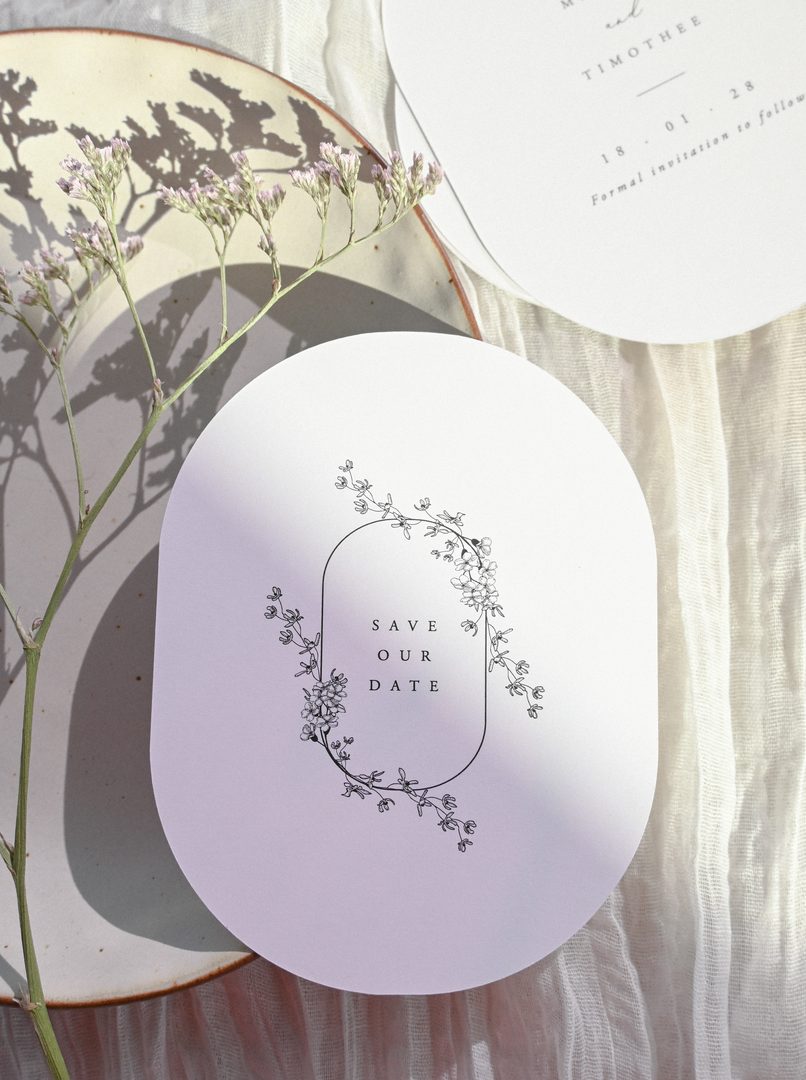 Paperlust invitation, Beautifully styled save-the-date card with delicate botanical line art on an oval-shaped card