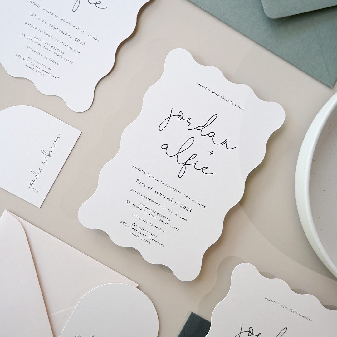 Paperlust invitation, Beautifully styled flatlay of a wavy-edge wedding suite featuring invitation