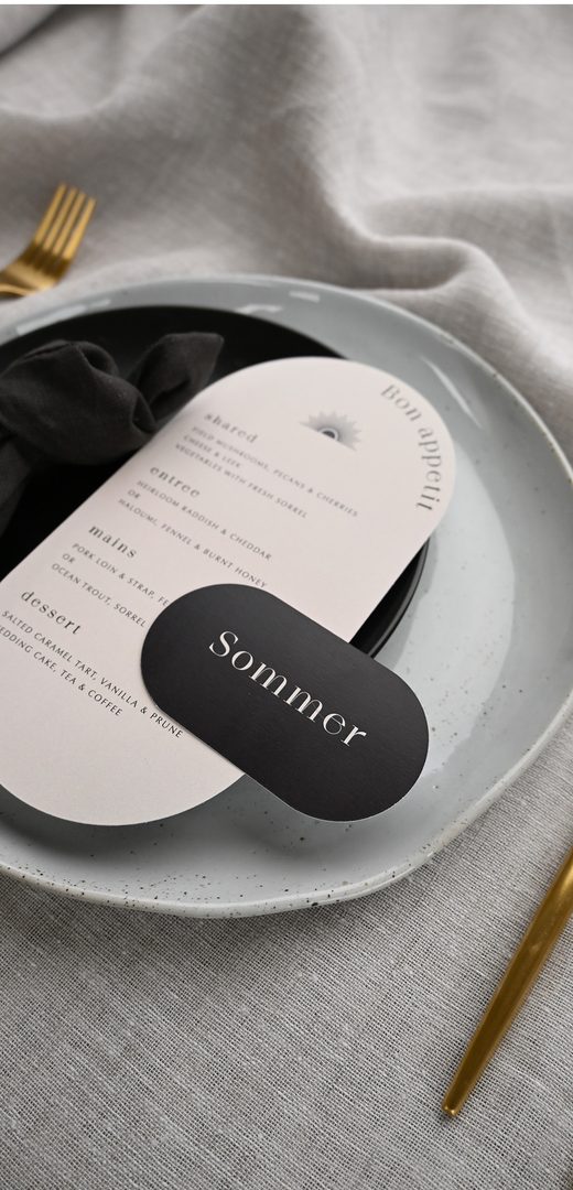 Paperlust menu, Beautifully styled place setting featuring a rounded menu card and black oval place card with the name 'Sommer'