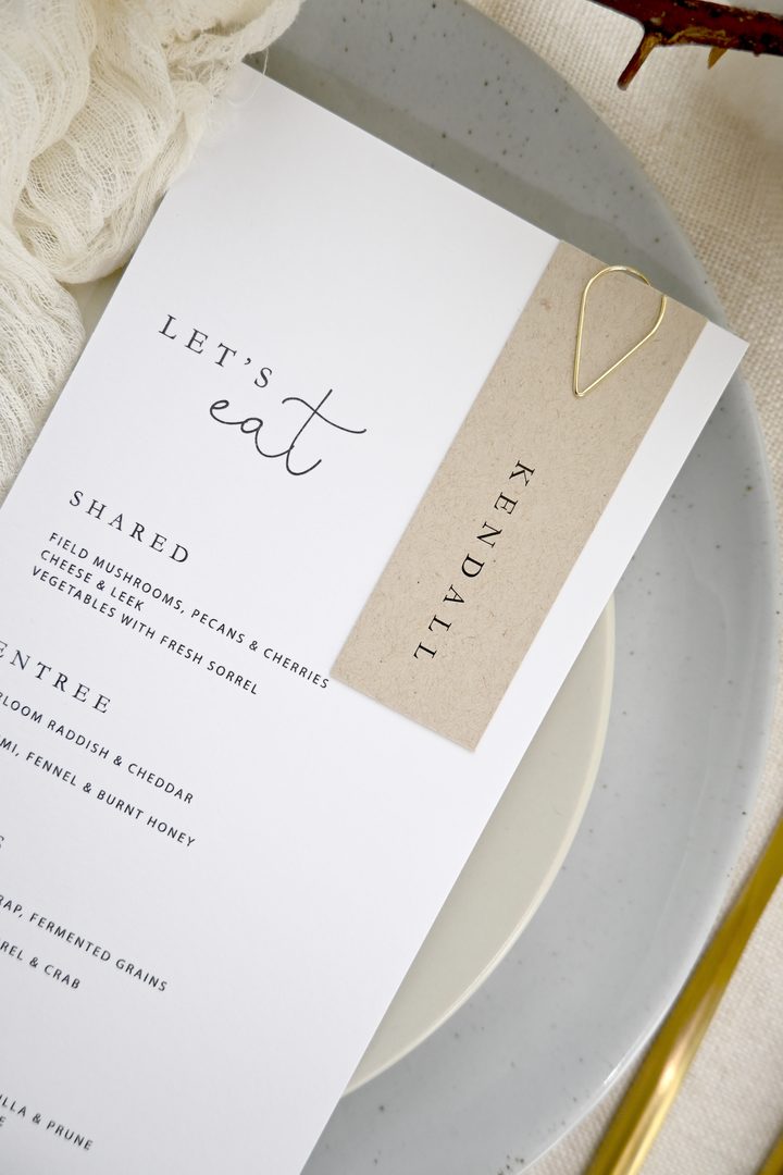 Paperlust menu, Beautifully styled flat lay of a wedding menu with an attached kraft paper place card for 'Kendall'