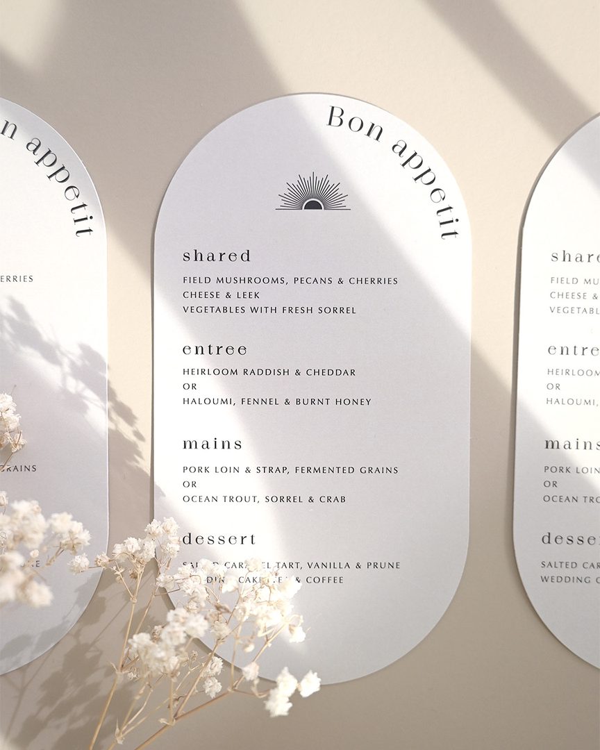Paperlust menu, Beautifully styled arch-shaped wedding menu cards with elegant typography and a sun motif