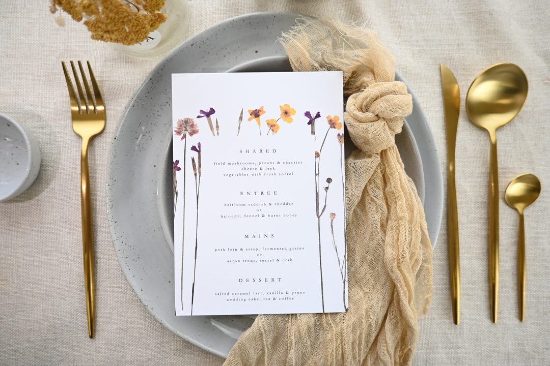 Paperlust program, Beautifully styled wedding menu flatlay with pressed flower illustrations