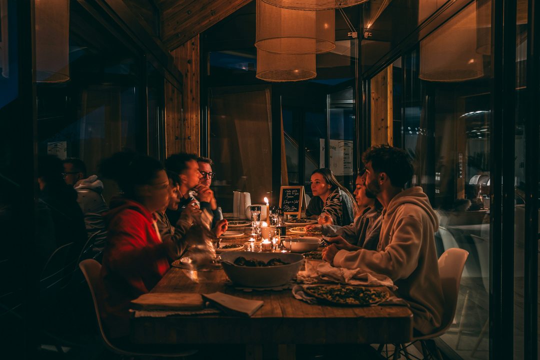 Wedding guests enjoying a warm candlelit reception dinner