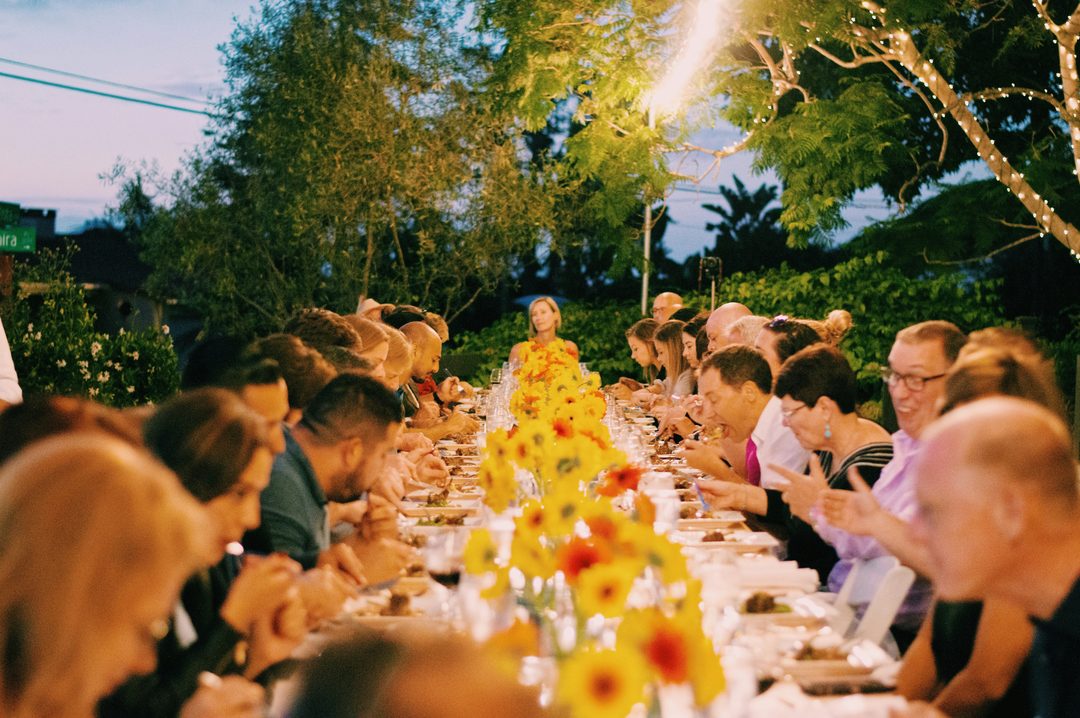 Wedding guests dining together at a long reception table