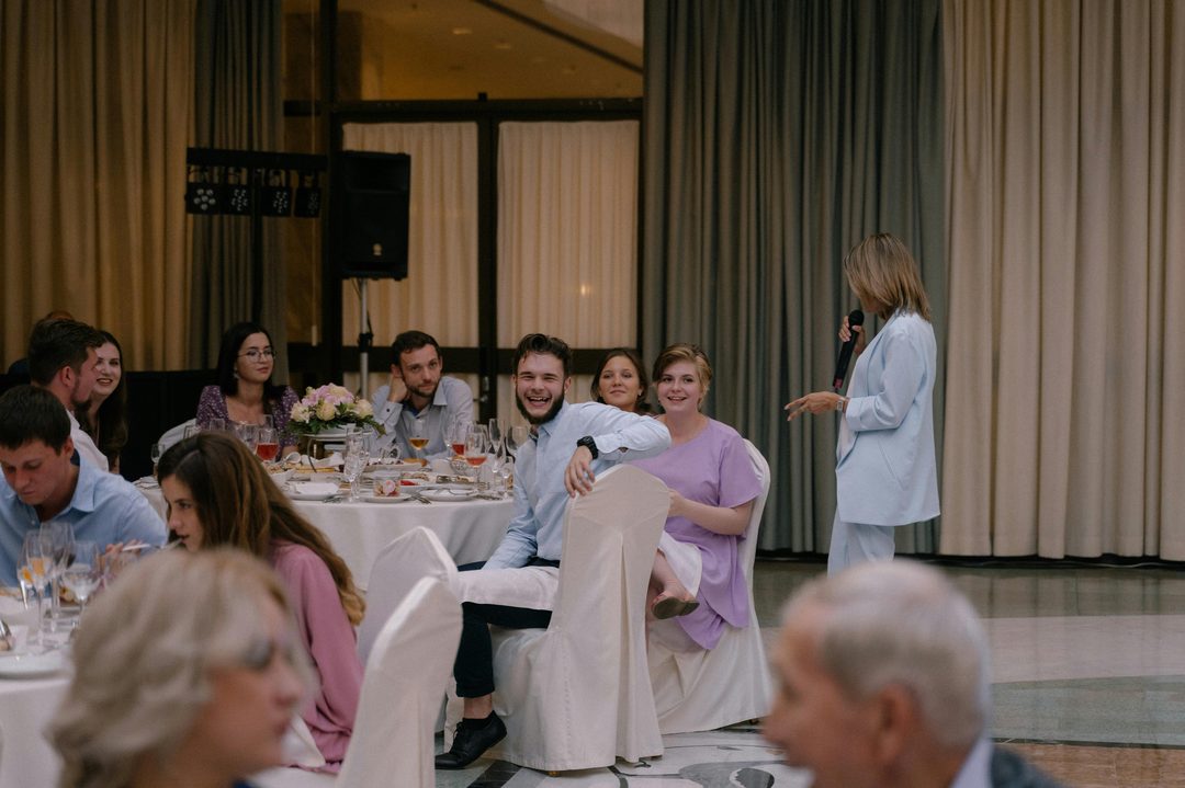 Wedding reception guests enjoying dinner and conversation indoors