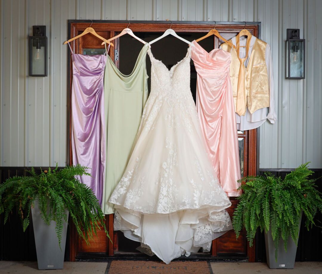Elegant floor-length gown in blush chiffon hanging in a sunlit dressing room at a bridal boutique, soft romantic interior...
