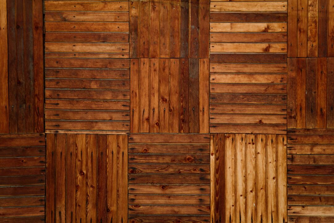 Close-up of a polished parquet wood dance floor surface at a wedding reception showing the grain and warm lighting,...