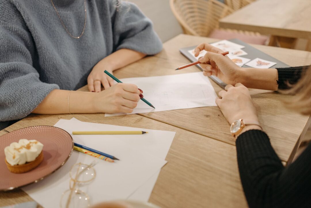 Wedding planner or coordinator AT WORK, reviewing planning documents, holding a clipboard/binder, or meeting with a...