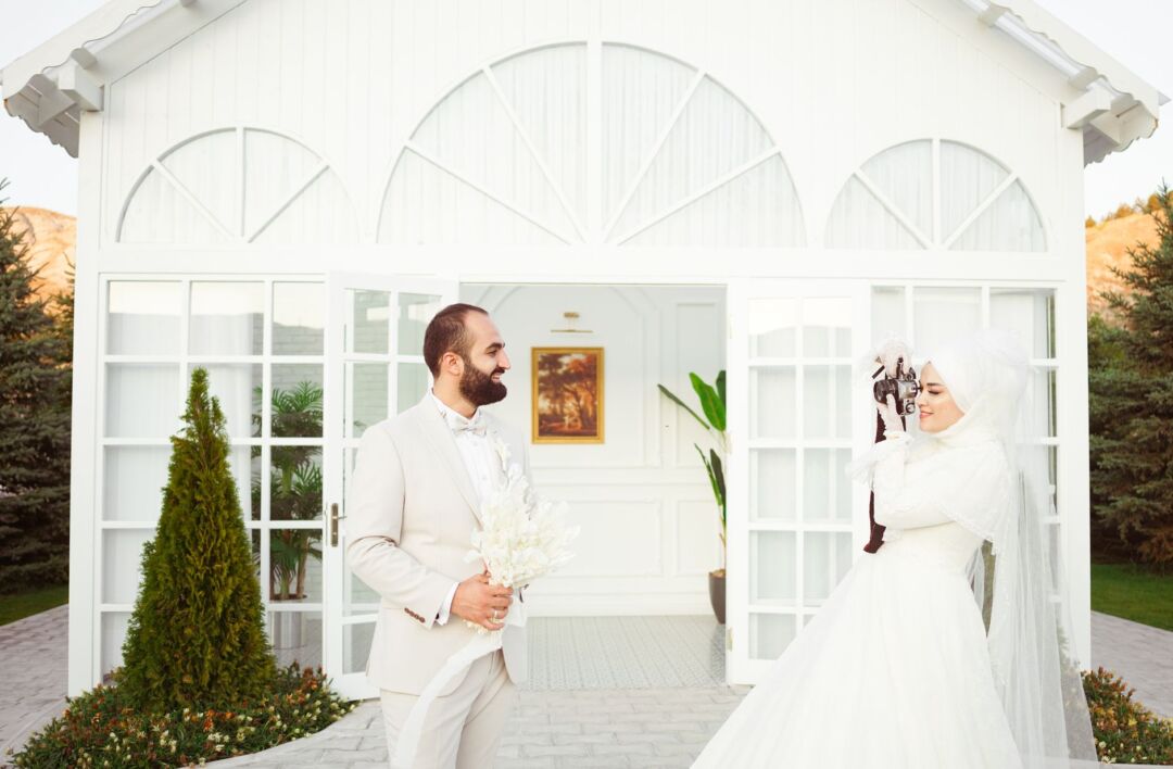 Couple standing outdoors at their wedding venue during a cloudy overcast afternoon, illustrating weather uncertainty and...