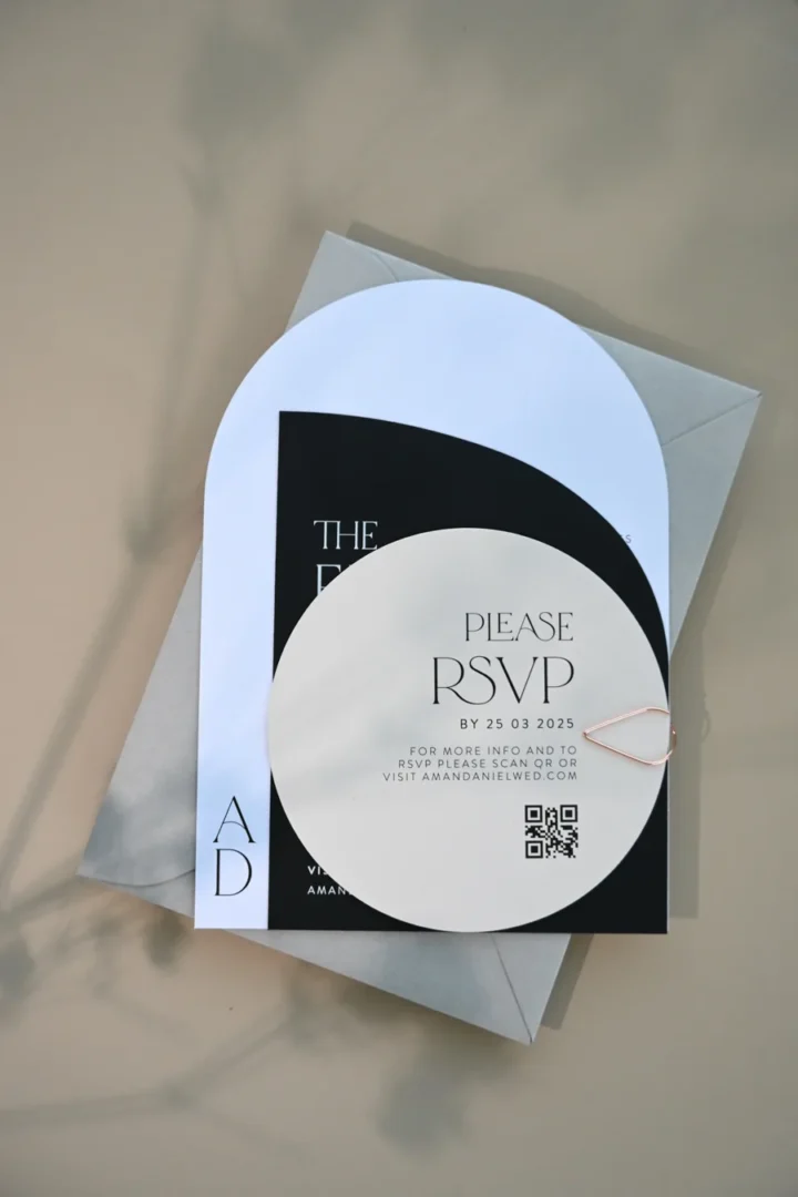Paperlust Delicate Luxe RSVP, a round almond card reading please RSVP by 25 03 2025 with QR code, layered over a black arch details card and pale grey envelope