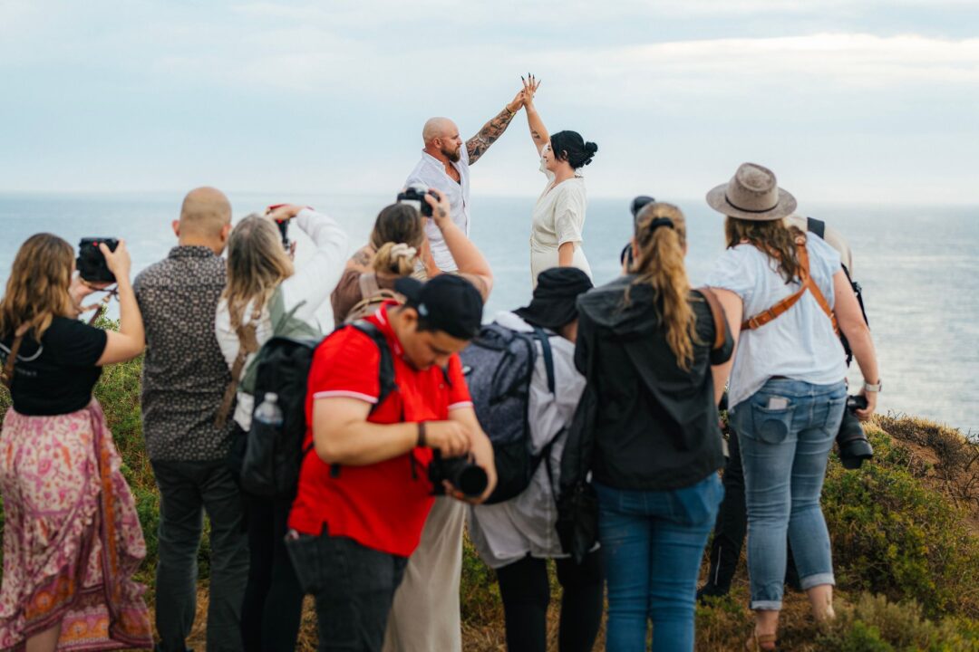 Wedding PHOTOGRAPHER or VIDEOGRAPHER at work, holding a camera or filming at a wedding