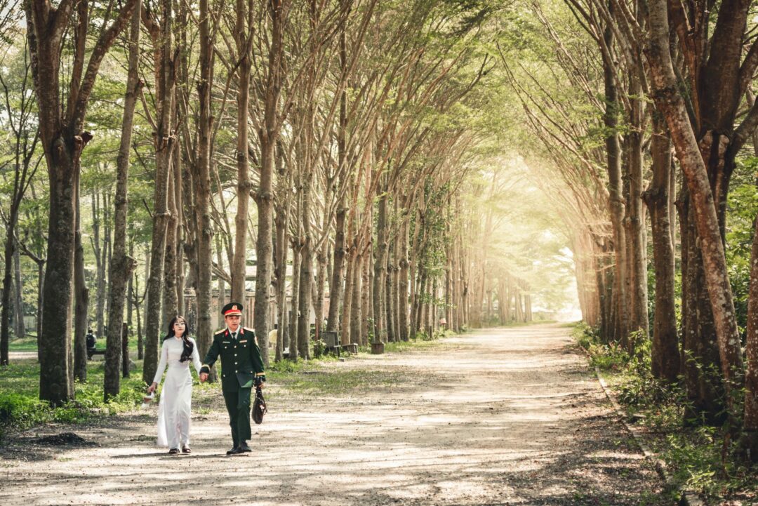 Couple walks hand in hand through a sun-dappled mountain meadow in Colorado, with no guests or officiant, holding their...