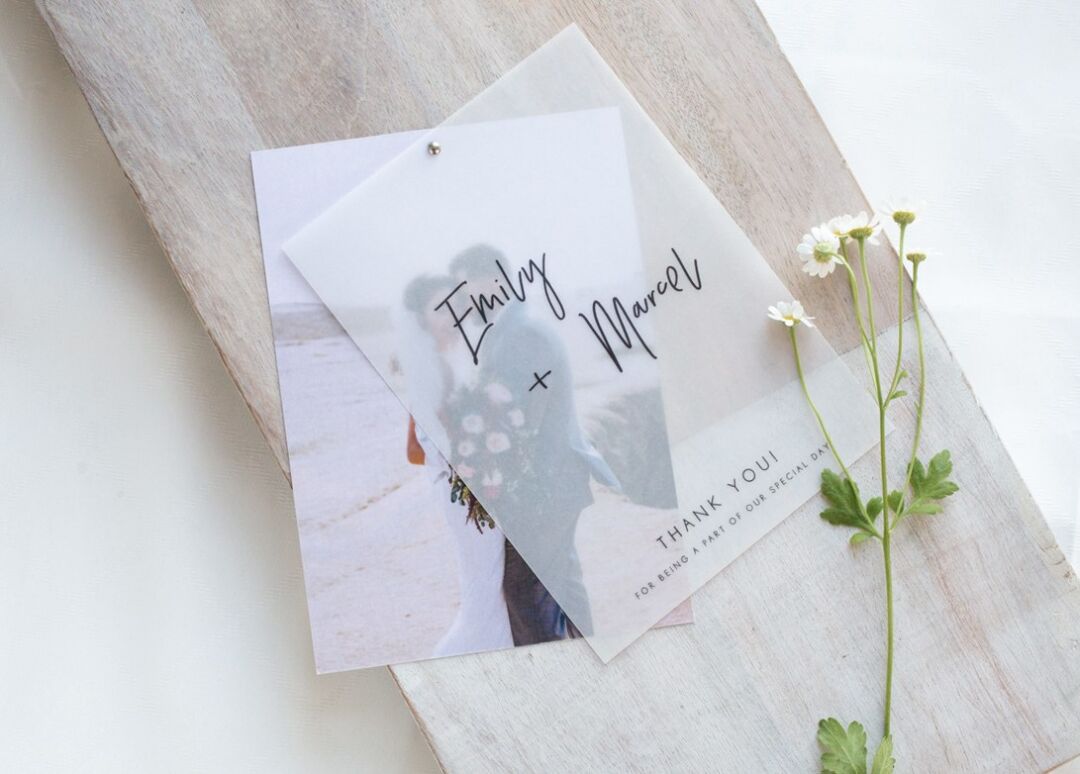 Clair de Lune photo thank you card with a vellum overlay reading Emily and Marcel, on limewashed timber with daisies, Paperlust