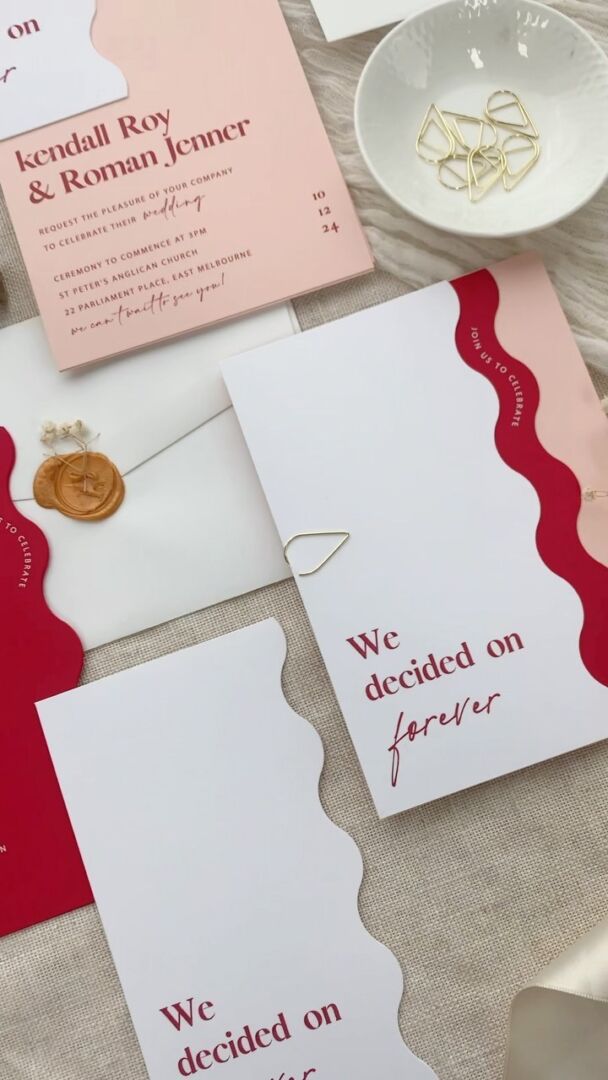 Flutter invitation set with red, pink and blush wavy die-cut cards.