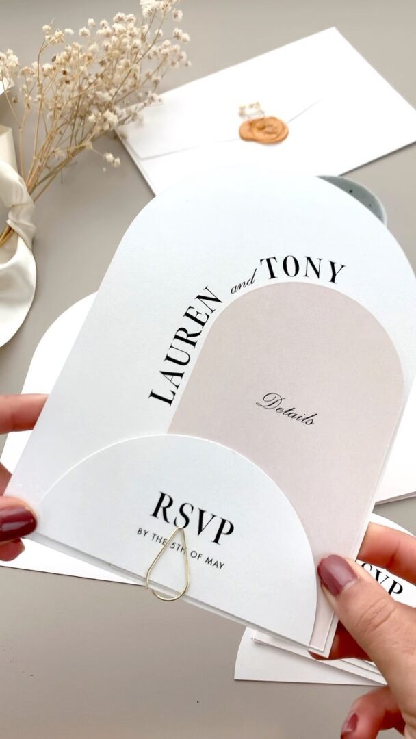 Arch-shaped invitation suite with die-cut cards, wax seal, and dried flowers.