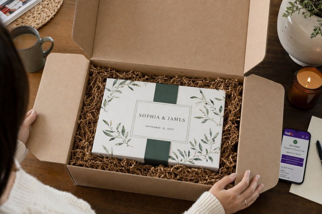 A gift box lid printed Sophia and James, September 18 2027, beside a phone showing a delivery confirmation.