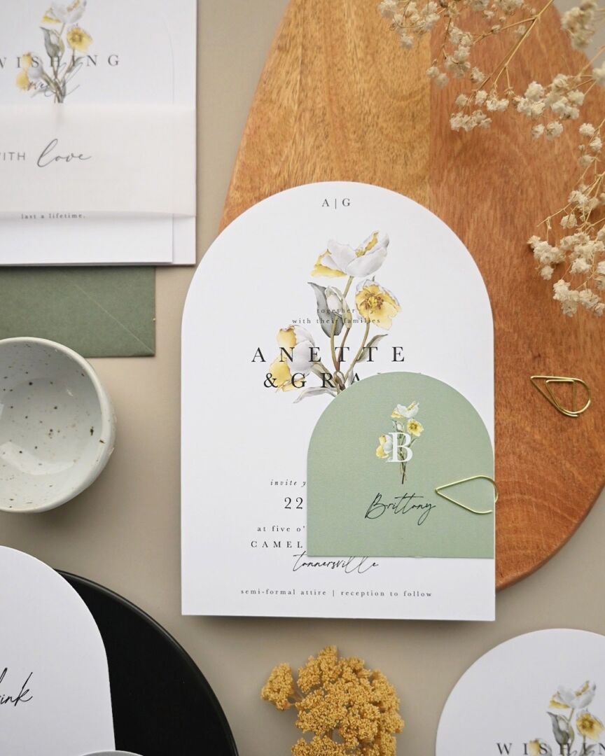 A Paperlust arch-shaped wedding invitation printed with yellow and white watercolour tulips.