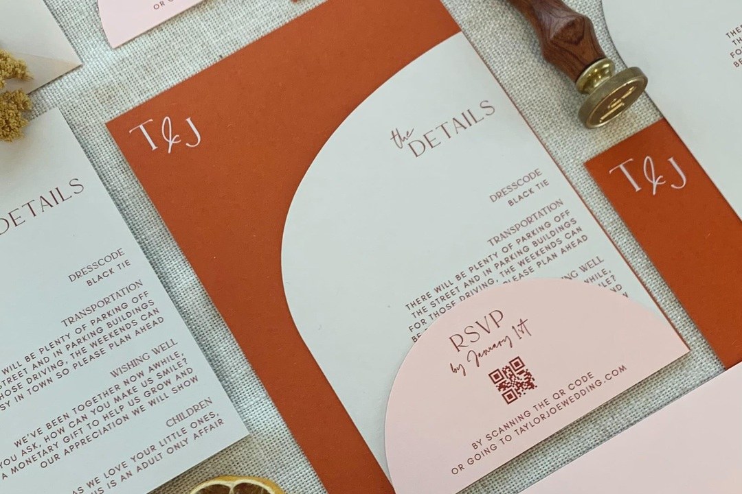 An autumn wedding invitation suite in terracotta and blush, a monogrammed main card beside a details card and an RSVP card with a QR code.