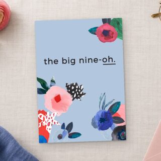 Paperlust Abstract Floral invitation in periwinkle blue with painted pink and red flowers reads the big nine oh on linen.